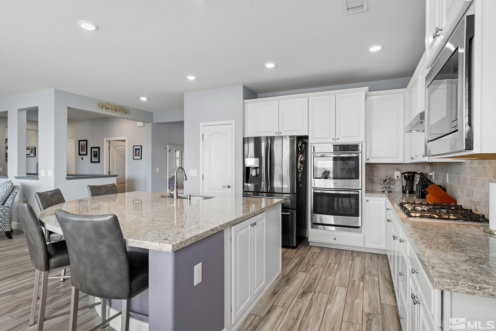 2811 McCauley Ranch Boulevard Reno, NV 89521 - Photo 14 of 40 a kitchen with stainless steel appliances granite countertop a kitchen island hardwood floor sink and stove