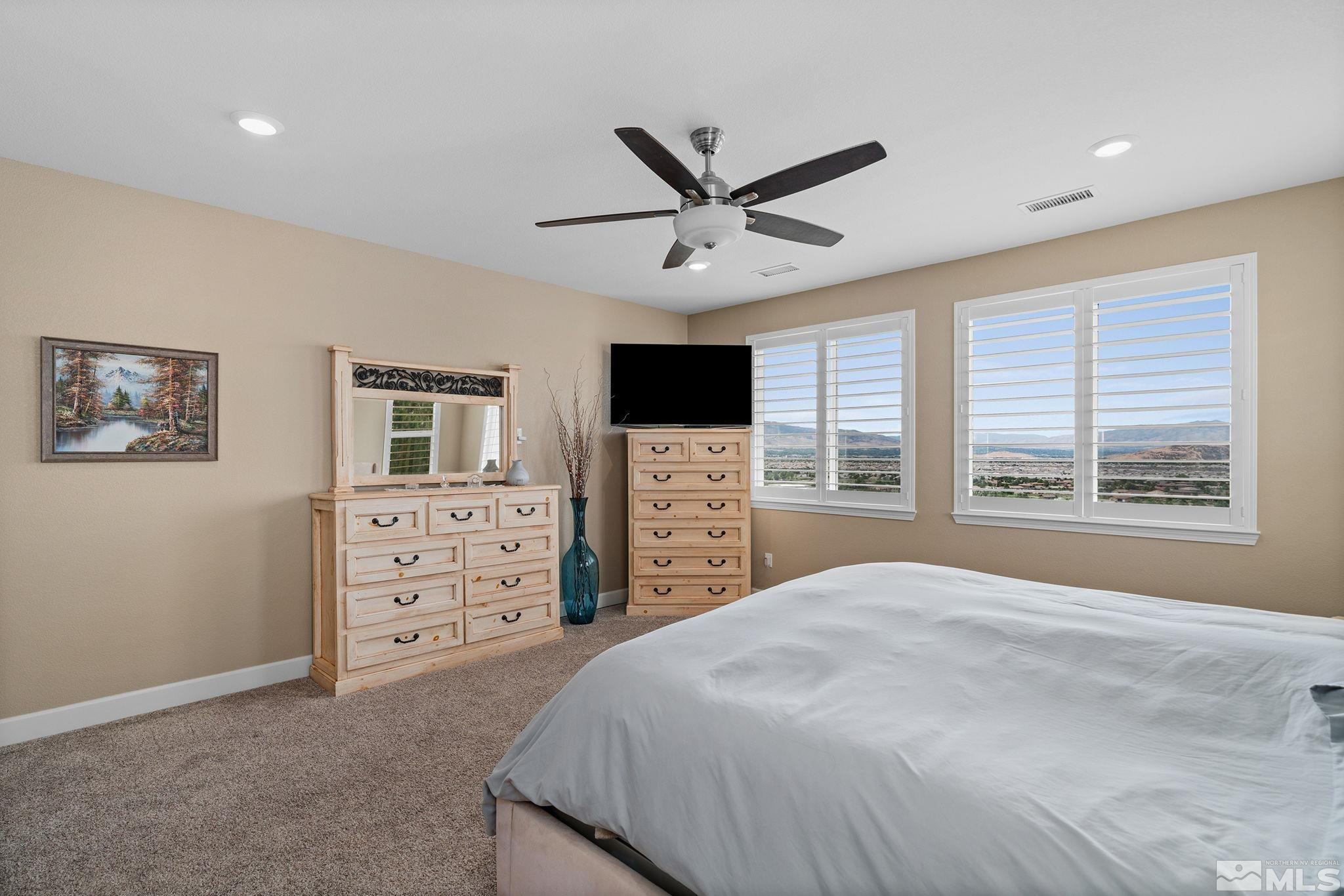 2811 McCauley Ranch Boulevard Reno, NV 89521 - Photo 18 of 40 a spacious bedroom with a large bed and a flat screen tv