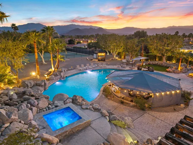 a view of a swimming pool with a yard and mountain view