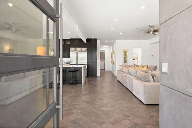 a living room with furniture a flat screen tv and a large window
