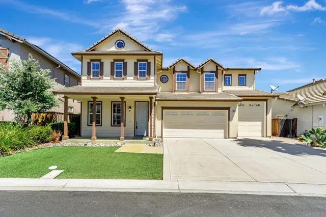 a front view of a house with a yard and garage