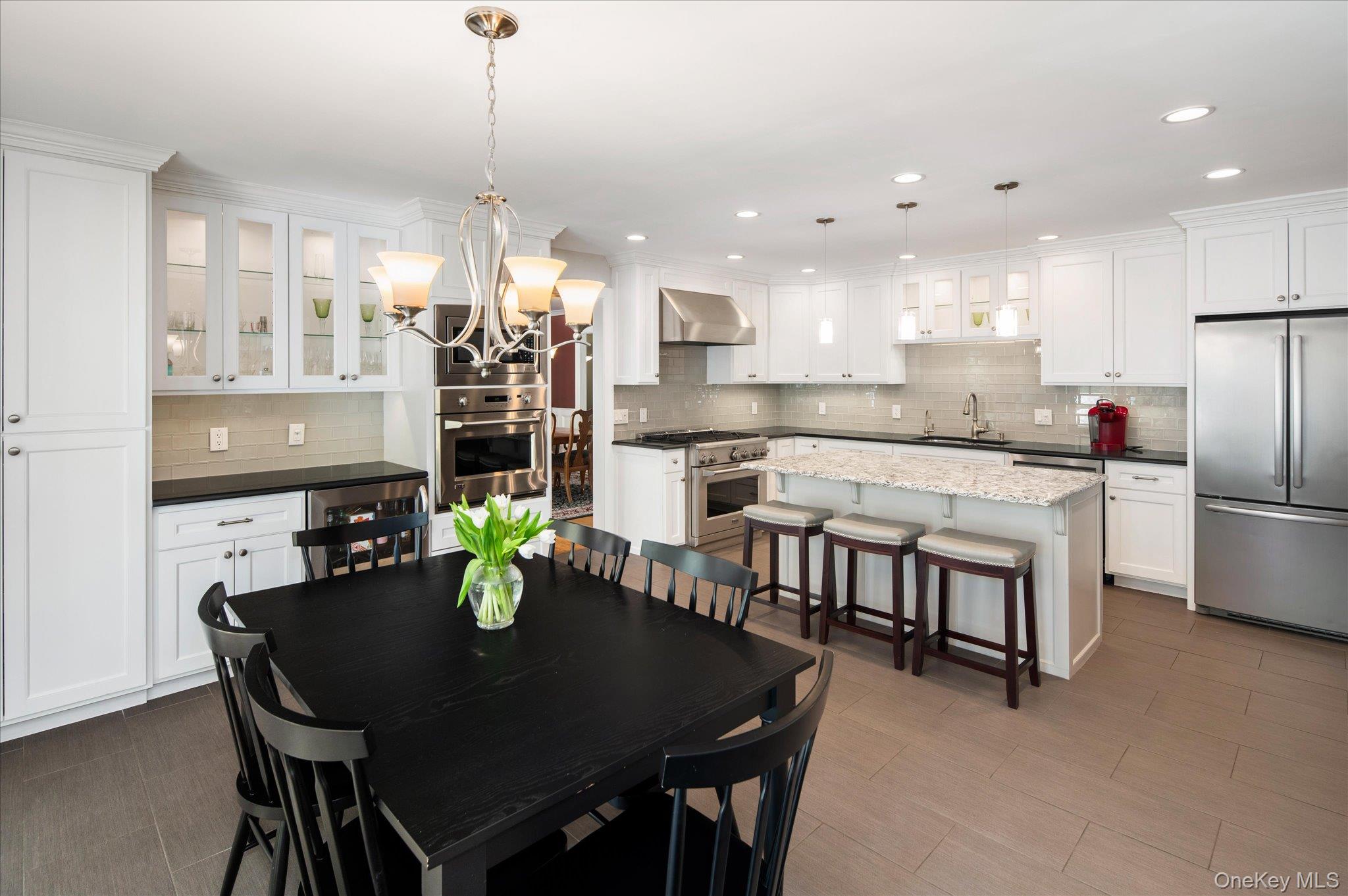 32 Watch Hill Road Croton-on-Hudson, NY 10520 - Photo 18 of 43 a kitchen with stainless steel appliances granite countertop a dining table chairs and white cabinets