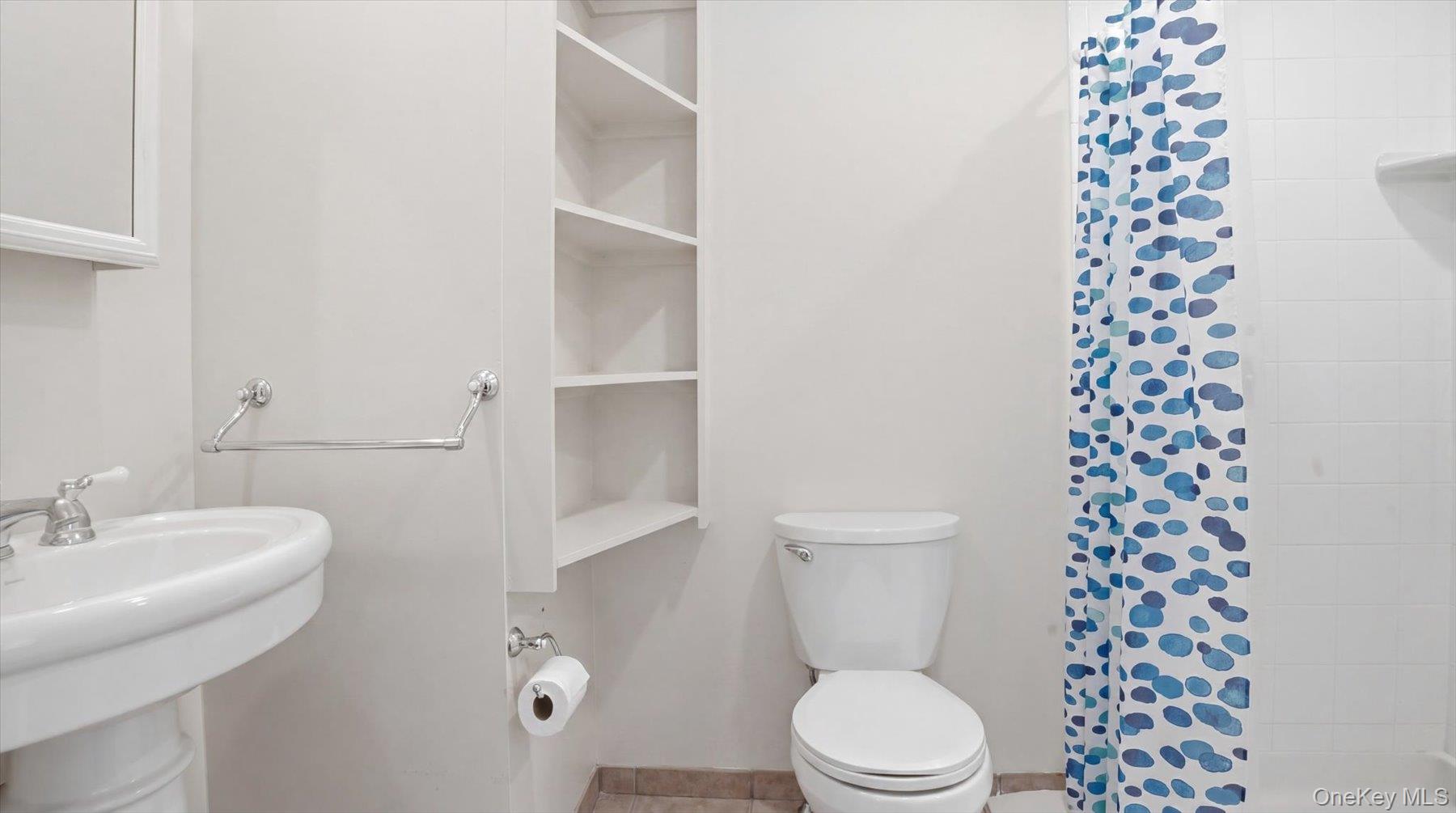 32 Red Creek Road Hampton Bays, NY 11946 - Photo 14 of 18 a white toilet sitting next to a bathroom sink