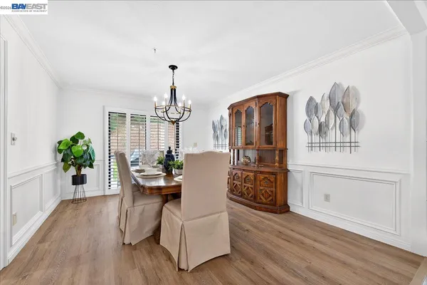 a dining room with furniture wooden floor a potted plant and wooden floor