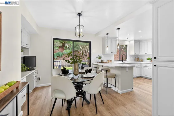 a dining room with wooden floor and stainless steel appliances
