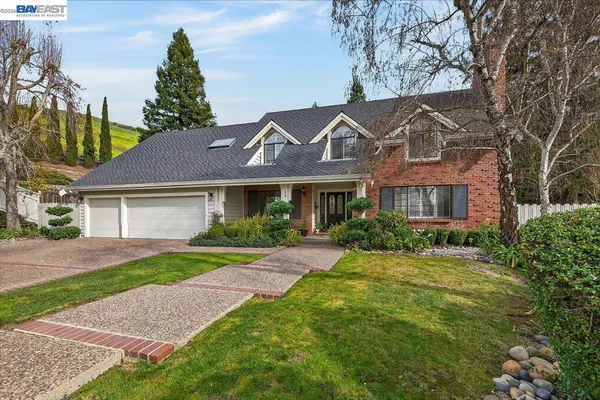 a front view of a house with a yard and potted plants