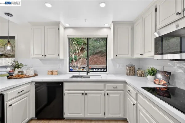 a kitchen with white cabinets and white appliances