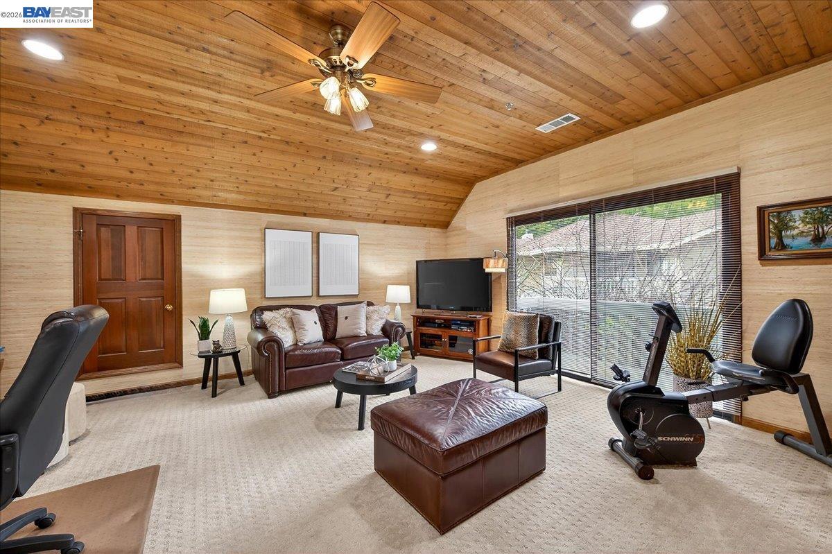 28 Harrington Road Moraga, CA 94556 - Photo 27 of 44 a living room with furniture a ceiling fan a fireplace and a large window