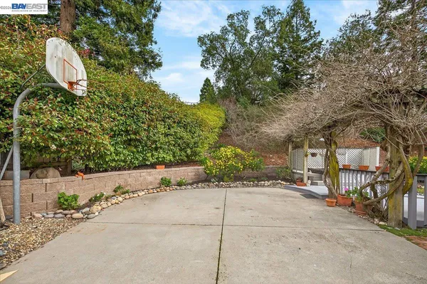 a backyard of a house with table and chairs under an umbrella