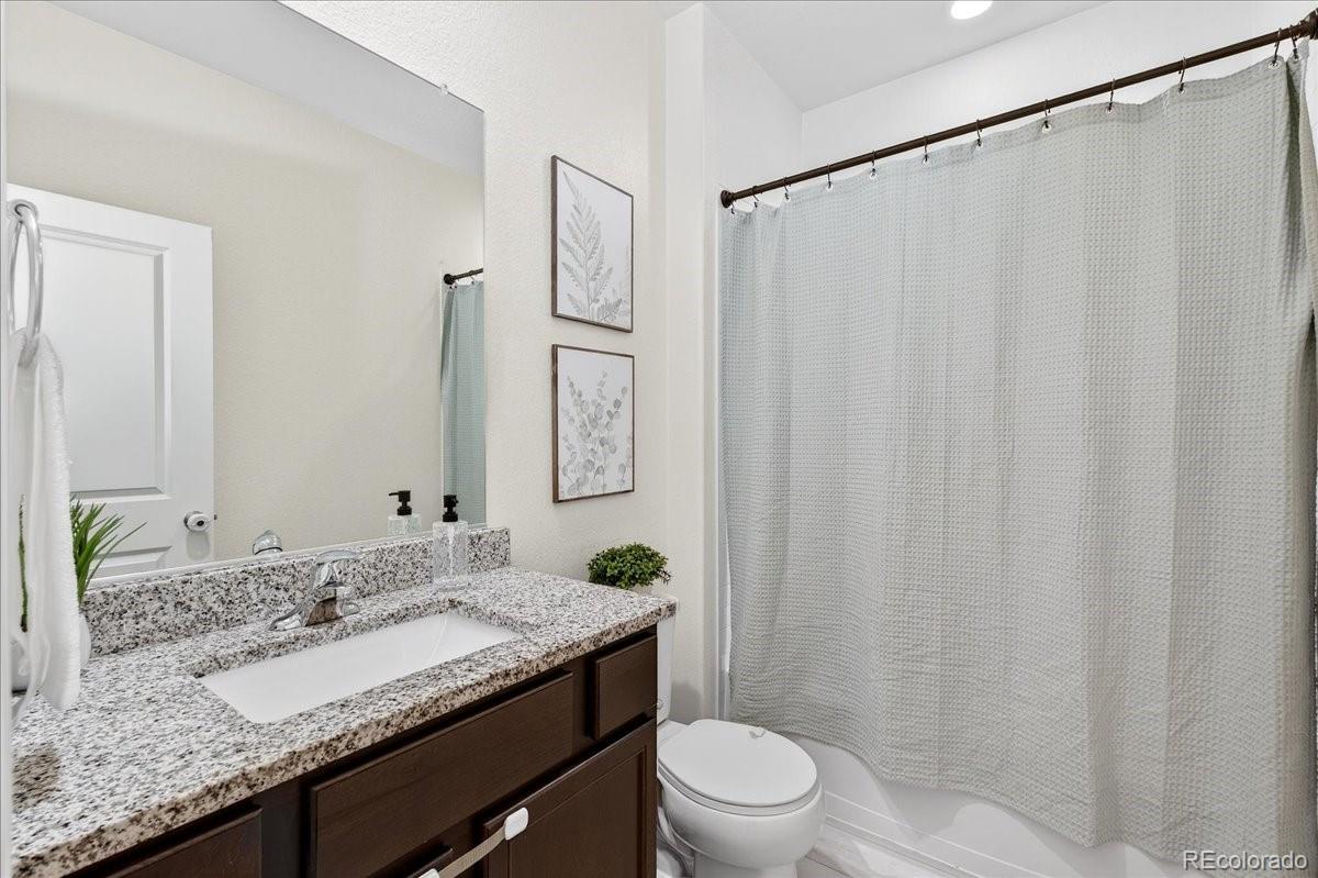 7227 Vermillion Street Frederick, CO 80530 - Photo 18 of 28 a bathroom with a granite countertop sink and a mirror