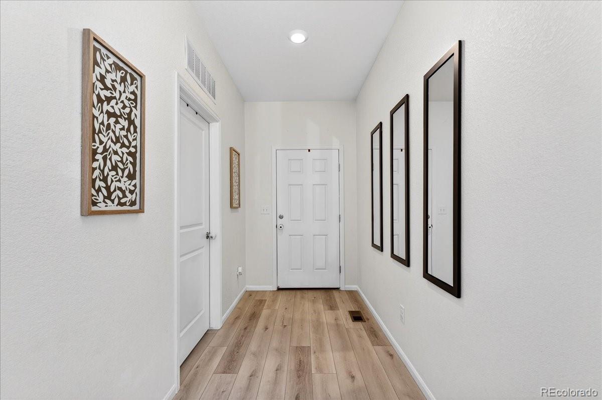 7227 Vermillion Street Frederick, CO 80530 - Photo 4 of 28 a view of a hallway with wooden floor and staircase