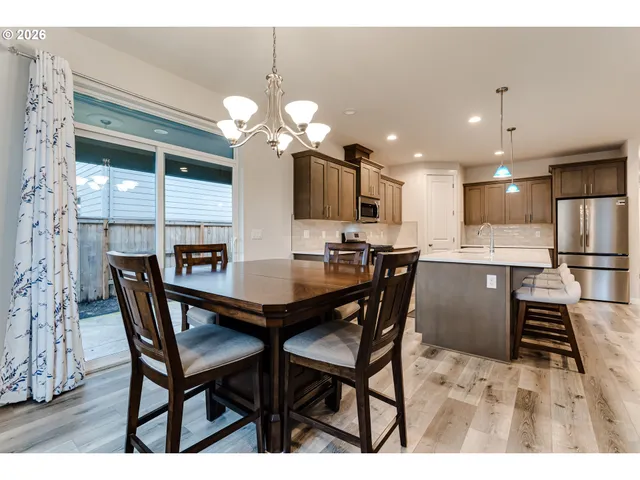 a dining room filled chandelier and kitchen view