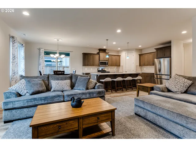 a living room with furniture kitchen view and a couch