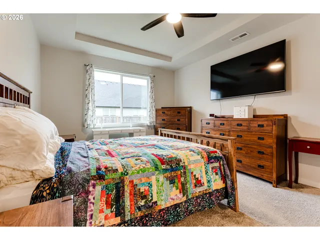 a bedroom with a bed a flat screen tv and a chandelier