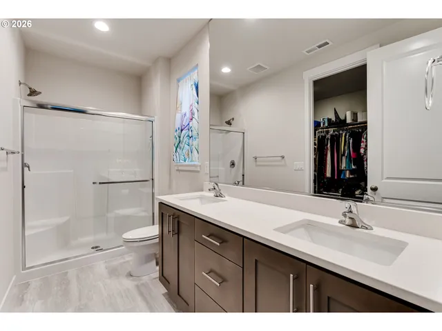 a bathroom with a sink double vanity granite tub shower and a mirror