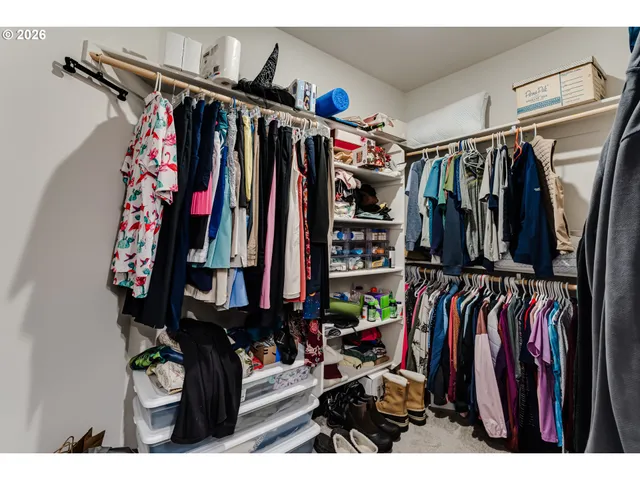 a view of walk in closet with clothes
