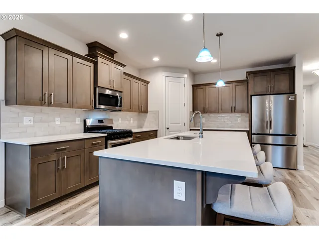 a kitchen with kitchen island a sink stainless steel appliances and cabinets
