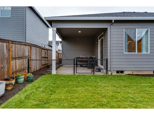 a backyard of a house with table and chairs