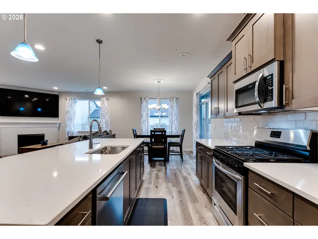 a kitchen with stainless steel appliances a stove sink microwave and cabinets