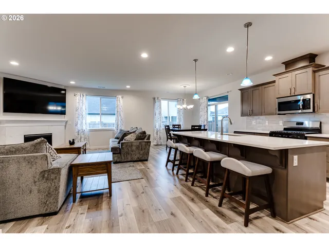 a living room with furniture a flat screen tv and kitchen view