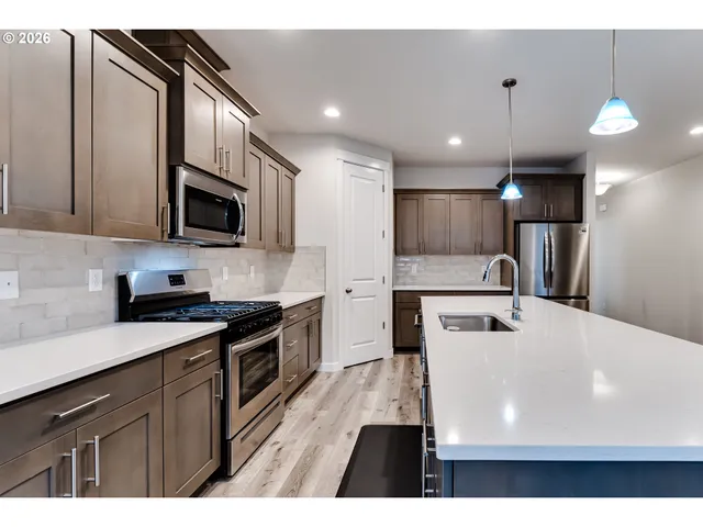 a kitchen with kitchen island a sink stainless steel appliances and cabinets