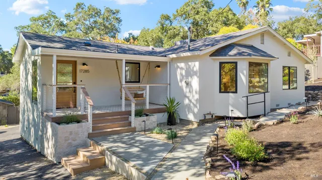 a view of a house with backyard and sitting area