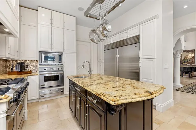 a view of a kitchen with granite countertop white cabinets and a sink