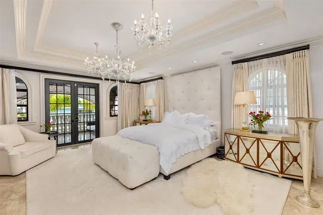 a spacious bedroom with a bed and a flat screen tv