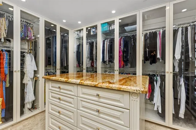 a view of walk in closet with clothes and shoes