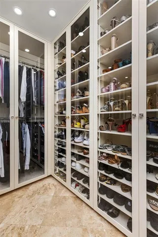 a view of walk in closet with clothes and shoes
