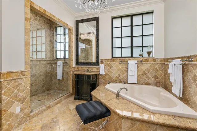 a bathroom with a tub a sink and a large mirror