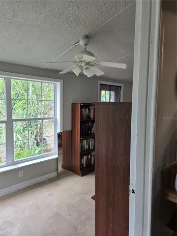 a living room with furniture a window and bookshelf