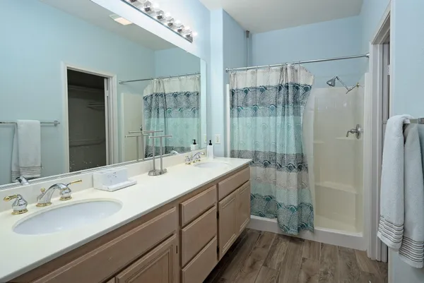 a bathroom with a double vanity sink mirror and shower
