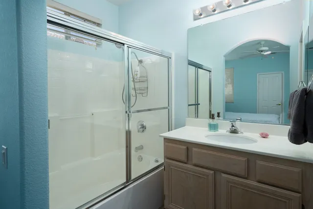 a bathroom with a shower sink vanity and mirror