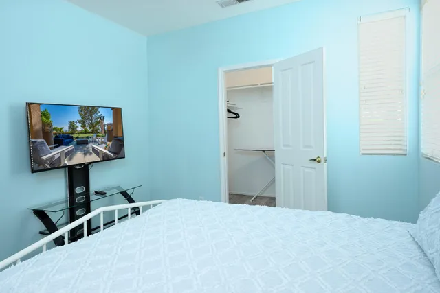 a bedroom with a bed and a flat screen tv