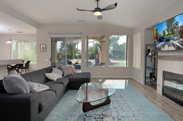 a living room with furniture a large window and a fireplace