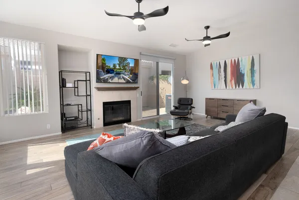a living room with furniture a flat screen tv and a fireplace