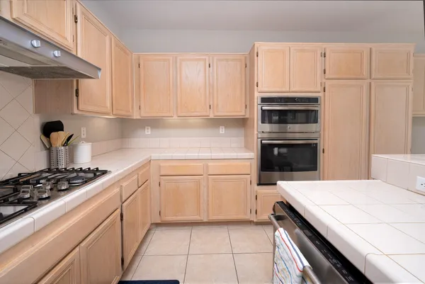 a kitchen with granite countertop a stove sink and cabinets