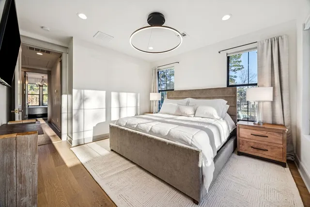 a bedroom with a large bed and a chandelier