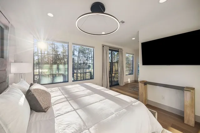 a spacious bedroom with a bed and a flat screen tv