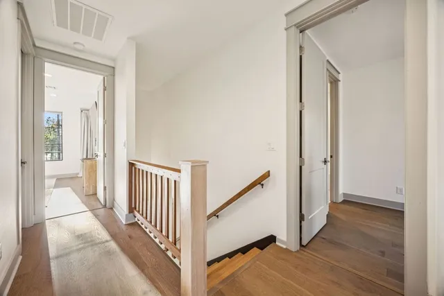 a view of a hallway with wooden floor and entryway