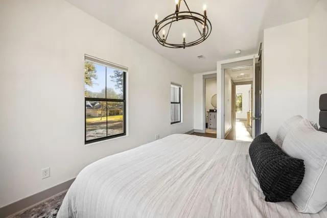a bedroom with a bed mirror and window