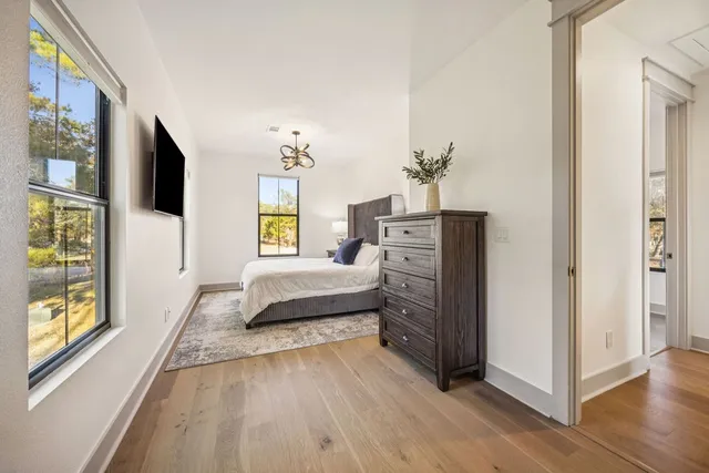 a spacious bedroom with a bed and wooden floor