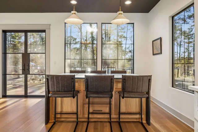 a dining room with furniture a chandelier and wooden floor