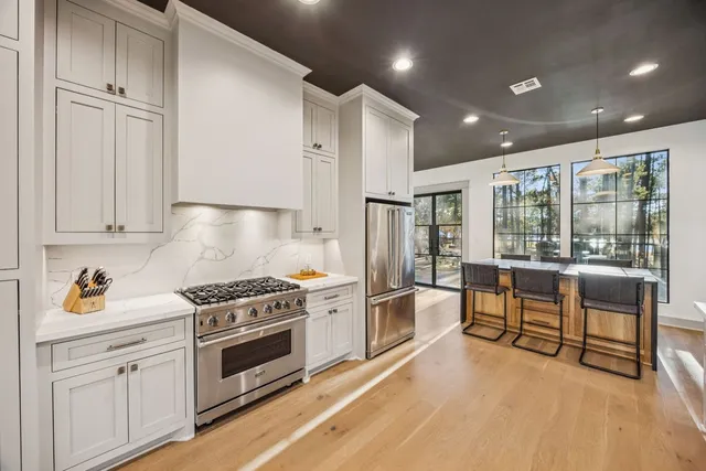 a kitchen with granite countertop a stove a sink and a refrigerator
