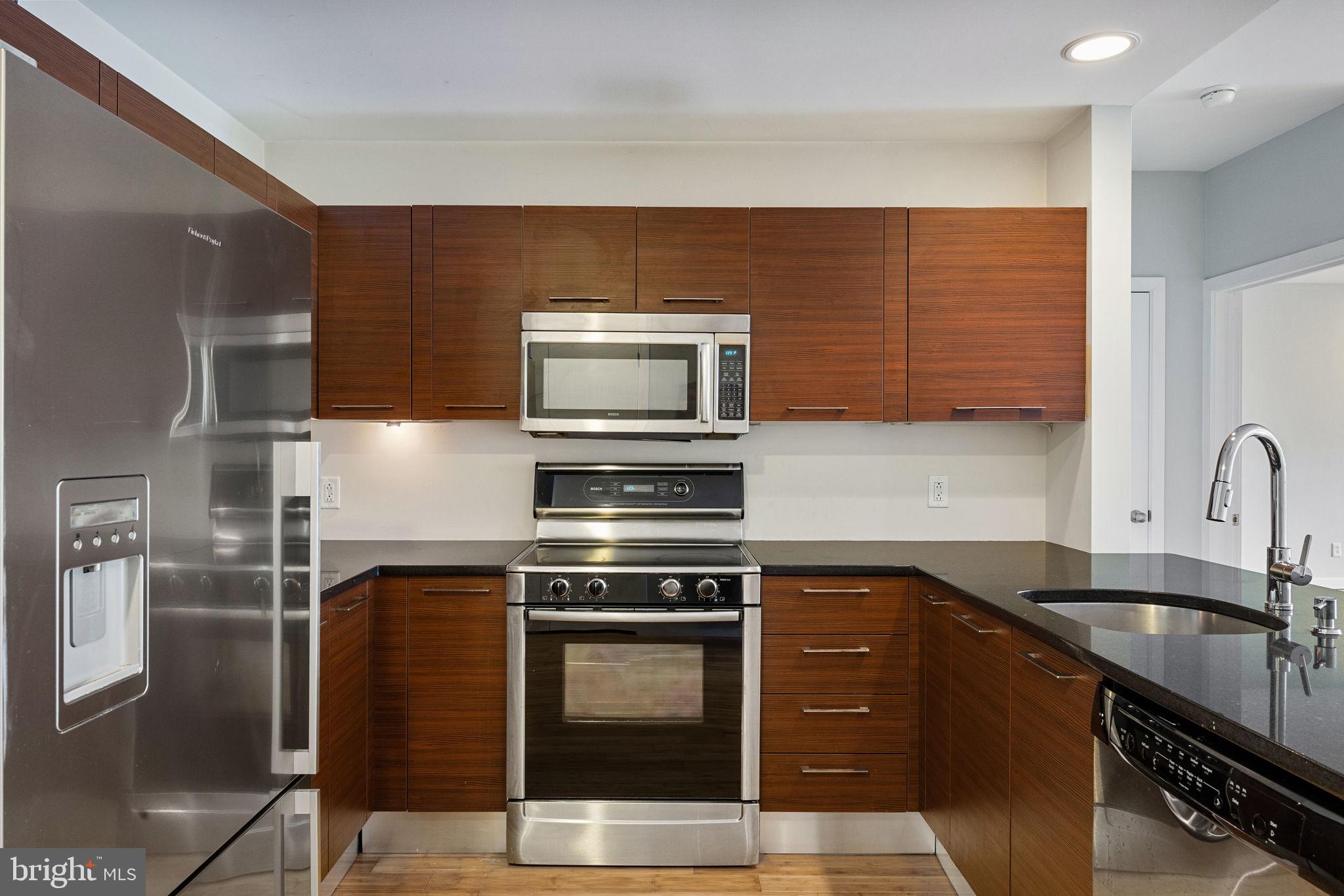 934 North 3rd Street, Unit 205 Philadelphia, PA 19123 - Photo 2 of 39 a kitchen with stainless steel appliances a stove a sink a microwave and refrigerator