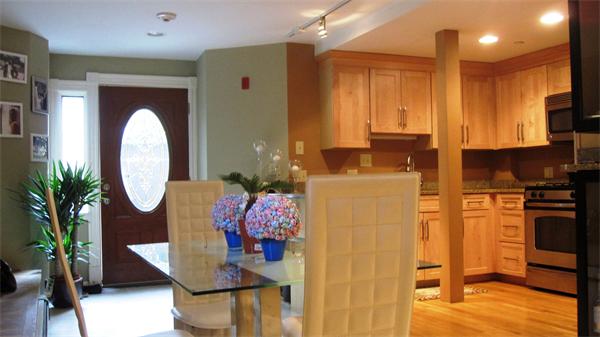 53 Corey Street, Unit B Everett, MA 02149 - Photo 27 of 30 a kitchen with stainless steel appliances granite countertop a stove a refrigerator and a dining table with wooden floor