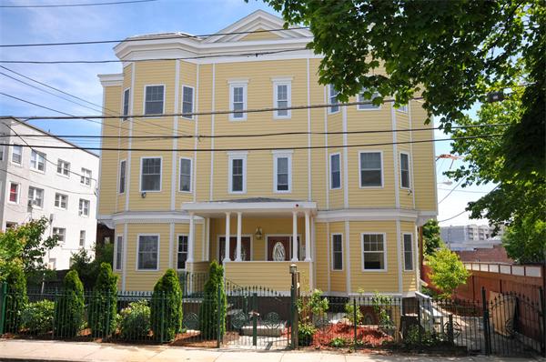 53 Corey Street, Unit B Everett, MA 02149 - Photo 3 of 30 a front view of a residential apartment building with a yard