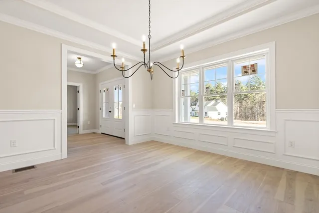 an empty room with wooden floor and window