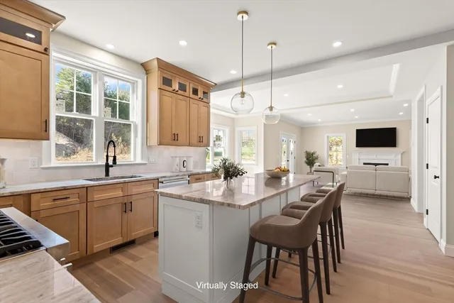 a kitchen with stainless steel appliances kitchen island granite countertop a sink a stove a dining table and chairs